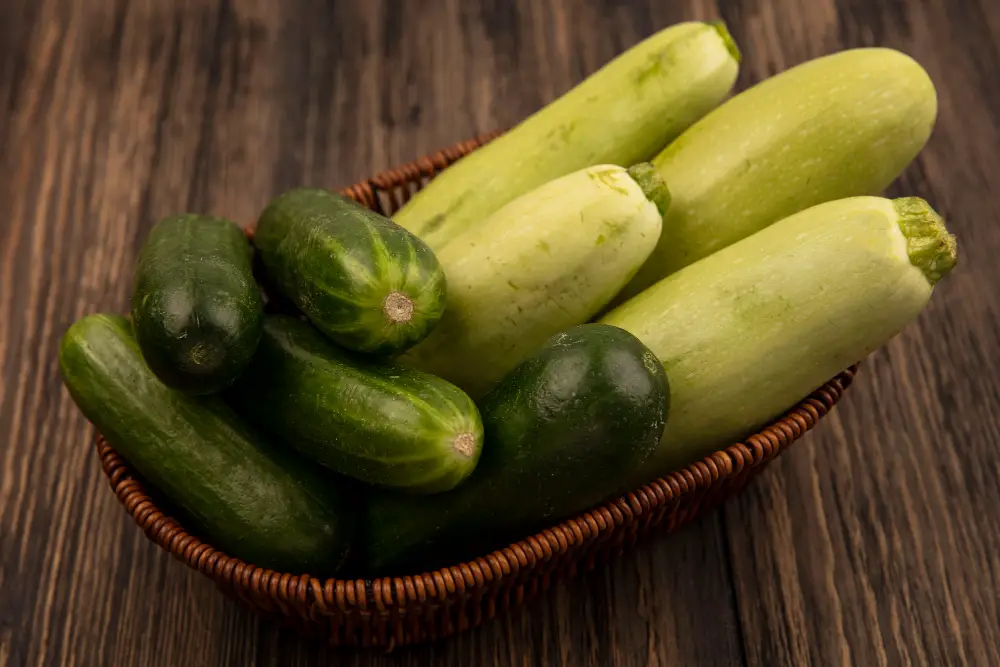 top-view-fresh-green-vegetables-such-as-zucchinis-cucumbers-bucket-wooden-surface